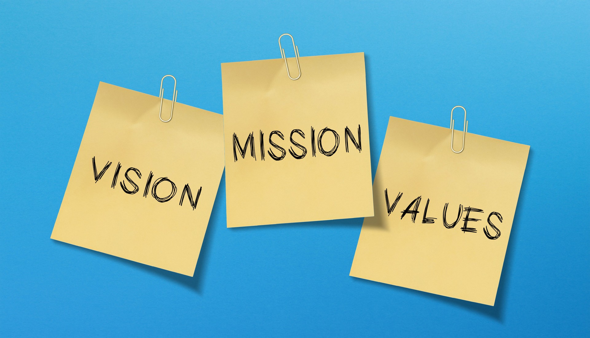 Business strategy and mission statement concept. The words mission, values and vision on adhesive note papers.