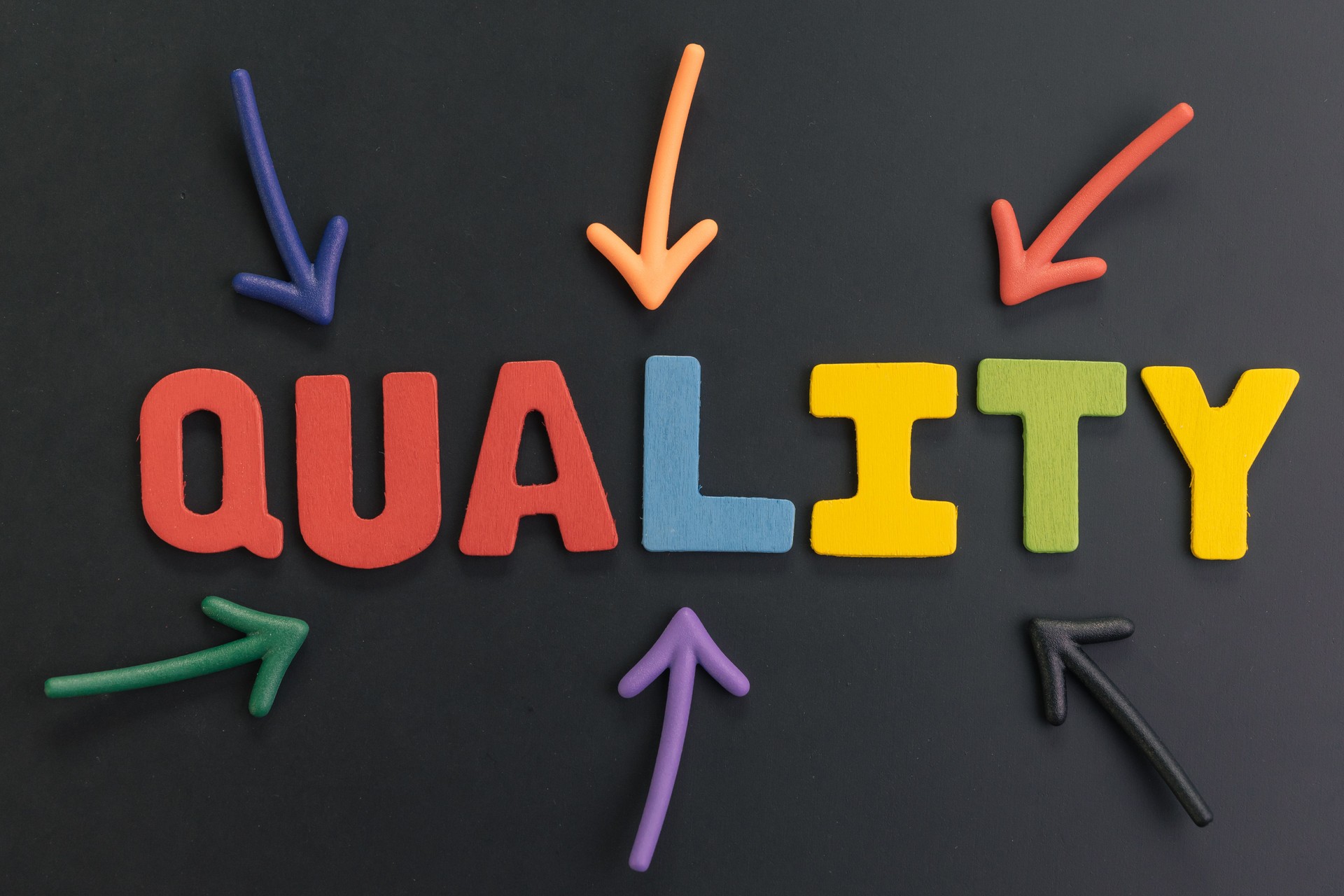 Important and awareness of quality concept, colorful arrows pointing to the word Quality at the center on black chalkboard