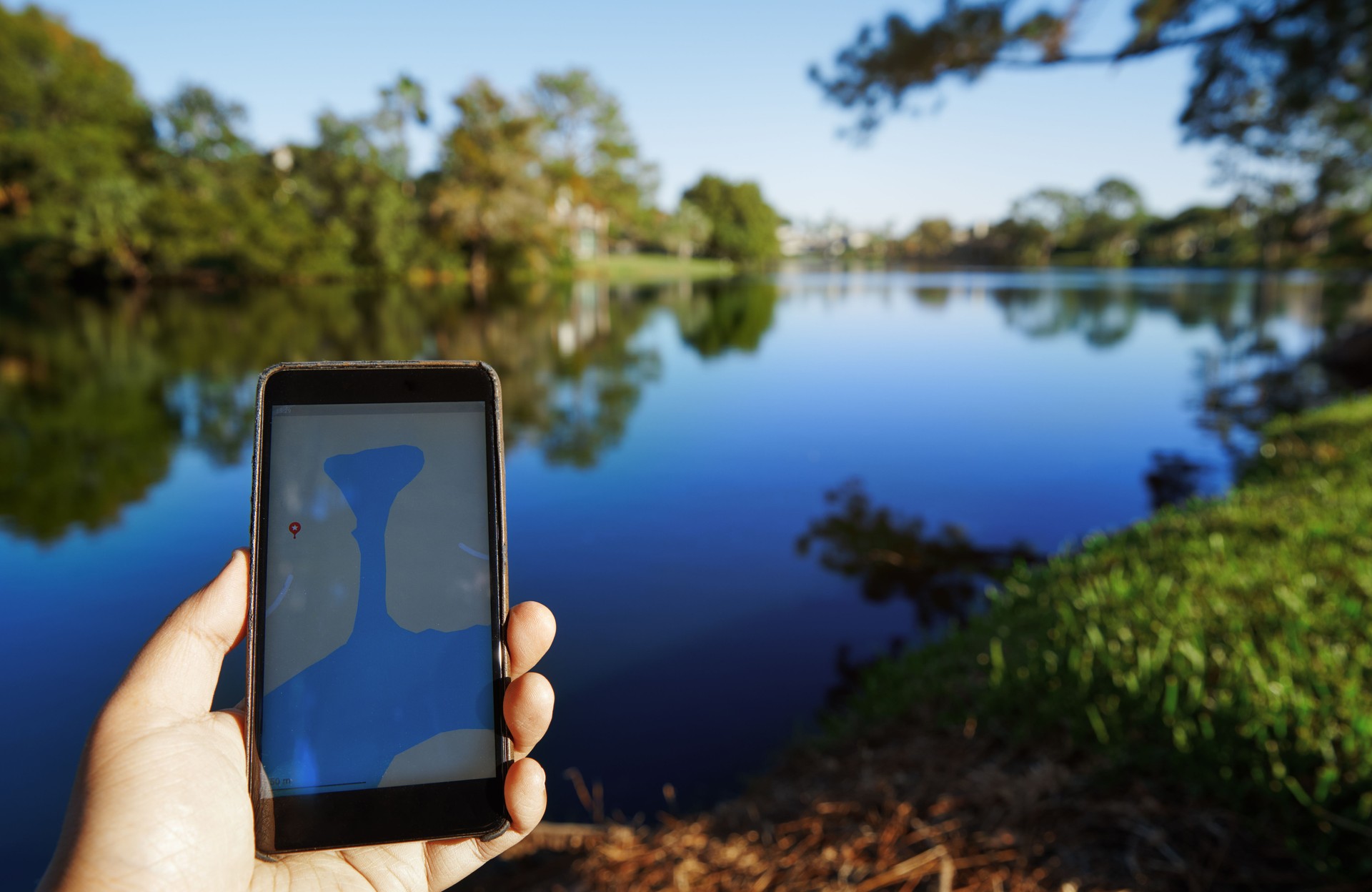 Man using mobile map app next to the lake