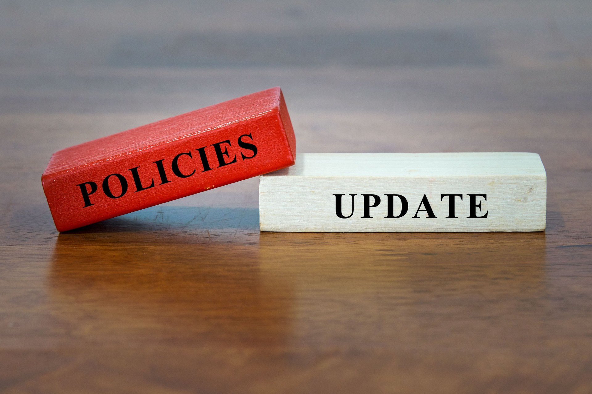 POLICIES UPDATE - text on wooden block.