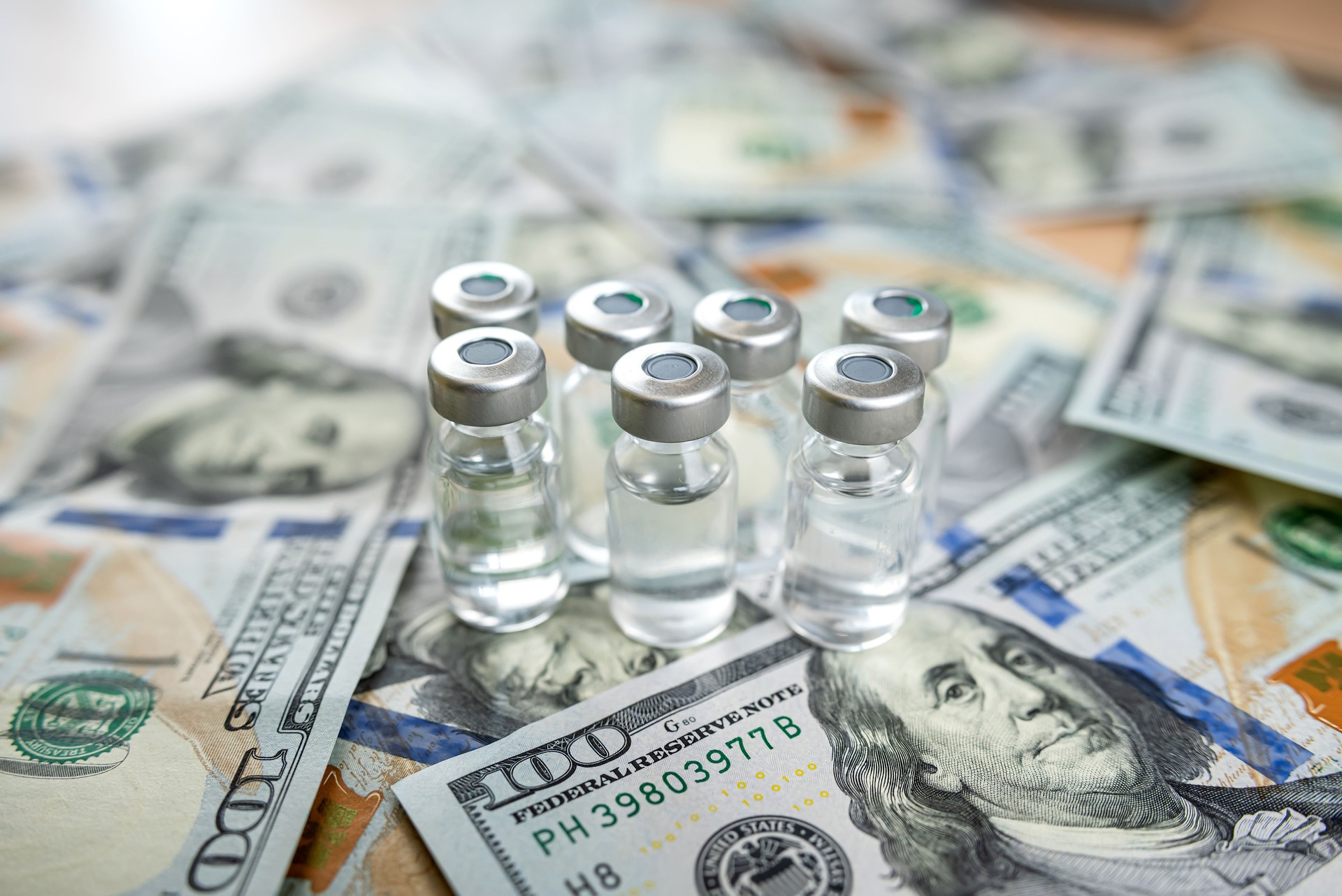 coronavirus vaccine or other in bottle on dollar paper background