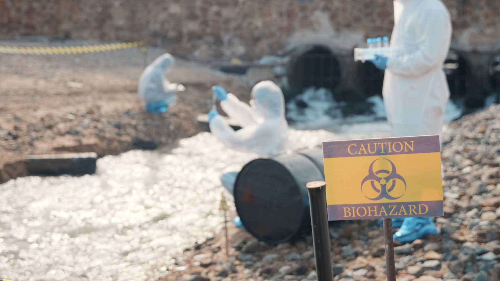 Closeup of chemical warning sign ecologist sampling water from the river in background